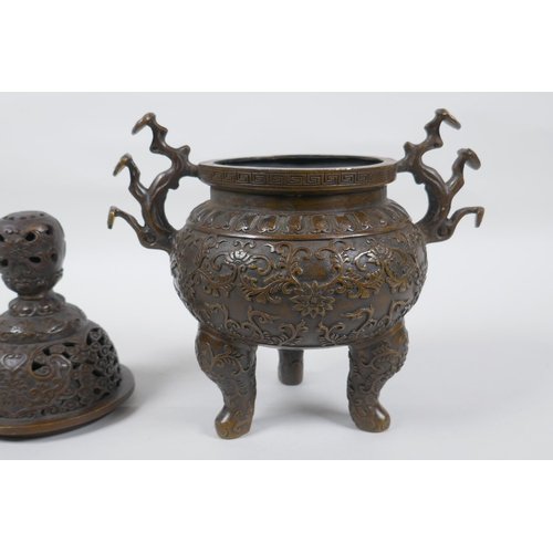 149 - A Chinese bronze censer and cover on tripod supports, with two ruyi shaped handles and allover lotus... 