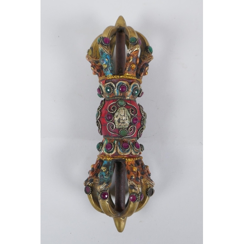 152 - A Tibetan ceremonial bronze vajra with painted details and stone settings, 23cm long