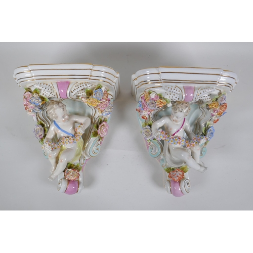 168 - A pair of Dresden style porcelain wall shelves decorated with putti and flowers, 24cm high