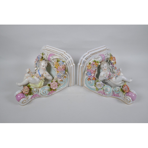 168 - A pair of Dresden style porcelain wall shelves decorated with putti and flowers, 24cm high