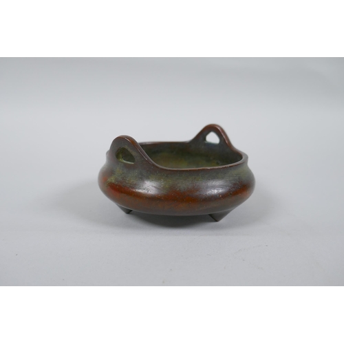 173 - A Chinese bronze censer with two phoenix eye handles and tripod supports, impressed seal mark to bas... 