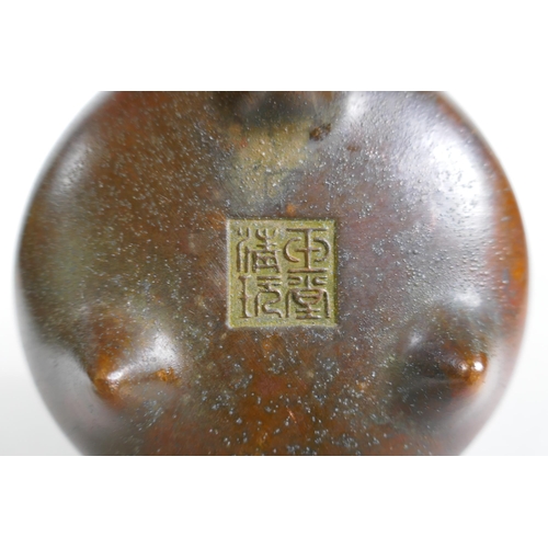 173 - A Chinese bronze censer with two phoenix eye handles and tripod supports, impressed seal mark to bas... 