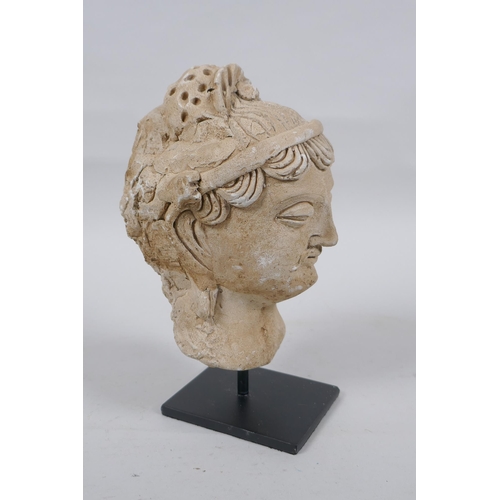 174 - A Gandahar style plaster bust, on a display stand, 18cm high