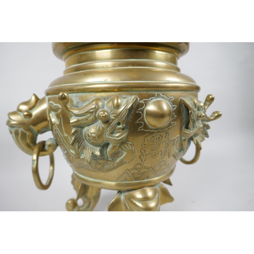 180 - A Chinese bronze censer and cover with tripod elephant head supports, twin dragon head loop handles,... 