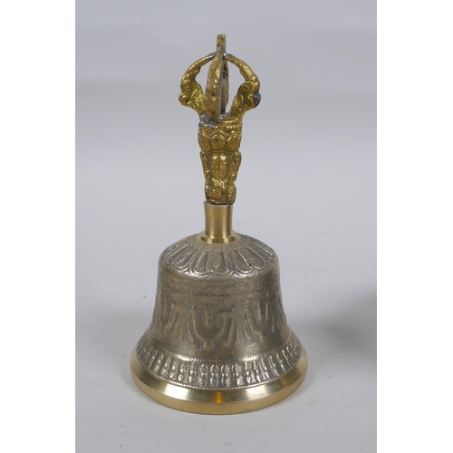 183 - A Tibetan bronze singing bowl with script decoration and wood beater, and a brass ceremonial bell wi... 