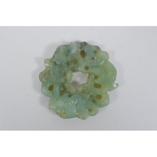 188 - A Chinese carved and pierced mottled green jade pendant with entwined carp decoration, 6cm diameter