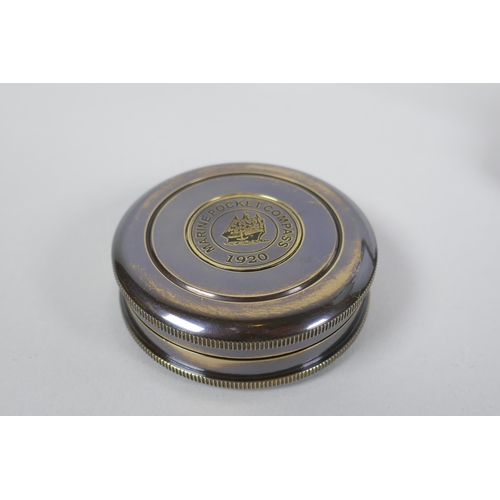 215 - A brass desk top magnifying glass and two reproduction brass compasses, lens 8cm diameter, 1AF