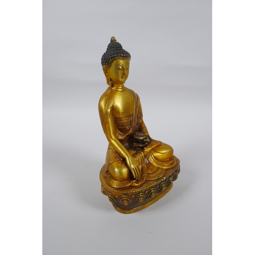 217 - A Tibetan gilt metal Buddha seated in meditation, double vajra mark to base, 20cm high