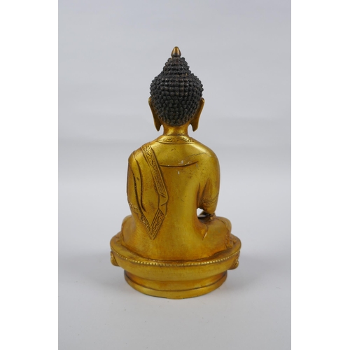 217 - A Tibetan gilt metal Buddha seated in meditation, double vajra mark to base, 20cm high