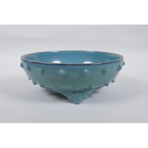 218 - A Chinese celadon glazed porcelain bowl raised on tripod supports, 21cm diameter