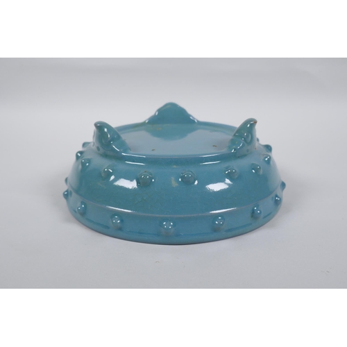 218 - A Chinese celadon glazed porcelain bowl raised on tripod supports, 21cm diameter