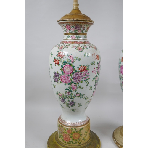 22 - A pair of famille rose porcelain vases converted to lamps, with matching painted bases, 67cm highest