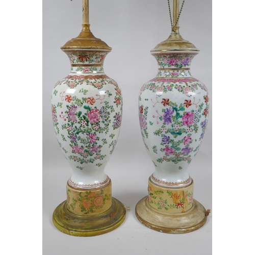 22 - A pair of famille rose porcelain vases converted to lamps, with matching painted bases, 67cm highest