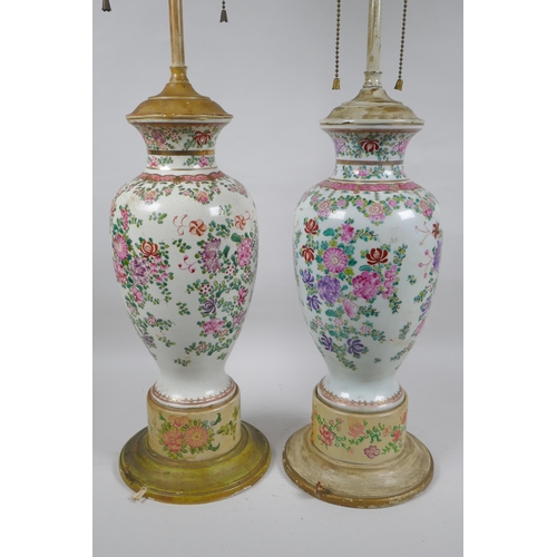 22 - A pair of famille rose porcelain vases converted to lamps, with matching painted bases, 67cm highest