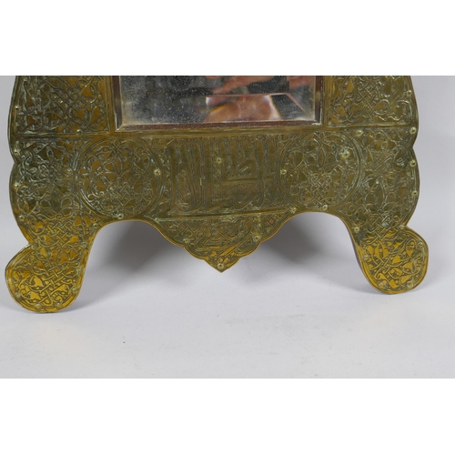 233 - An Islamic brass and hardwood wall mirror with engraved script and scrolling decoration, 33 x 60cm