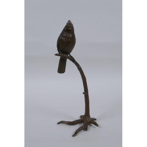 235 - A bronze figure of a bird perched on a tree, 19cm high