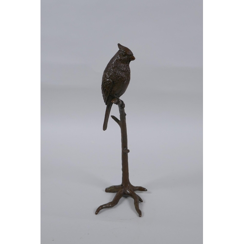 235 - A bronze figure of a bird perched on a tree, 19cm high