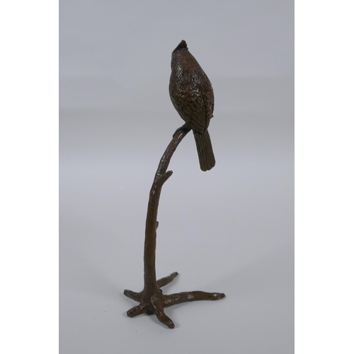 235 - A bronze figure of a bird perched on a tree, 19cm high