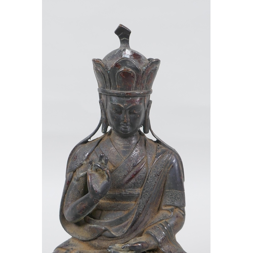 239 - A Sino Tibetan bronze figure of Buddha with the remnants of lacquered patina, 25cm high