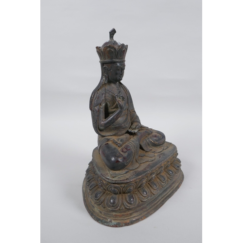 239 - A Sino Tibetan bronze figure of Buddha with the remnants of lacquered patina, 25cm high