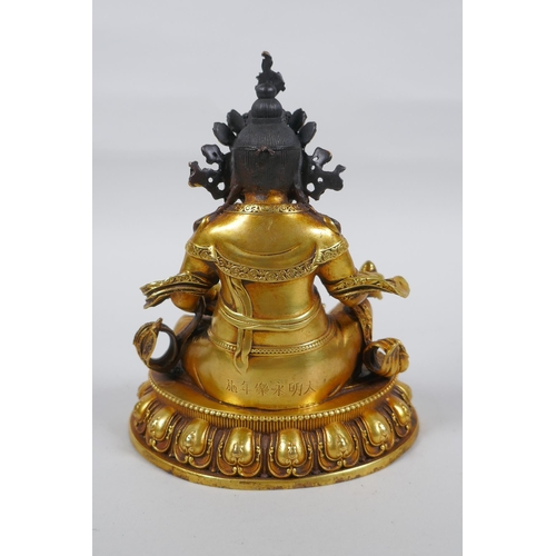 25 - An antique Sino Tibetan heavy gilt bronze figure of Jambhala seated on a lotus throne, double vajra ... 