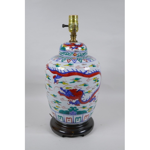 250 - A Chinese Wucai porcelain jar and cover with dragon decoration, converted to a lamp, 41cm high