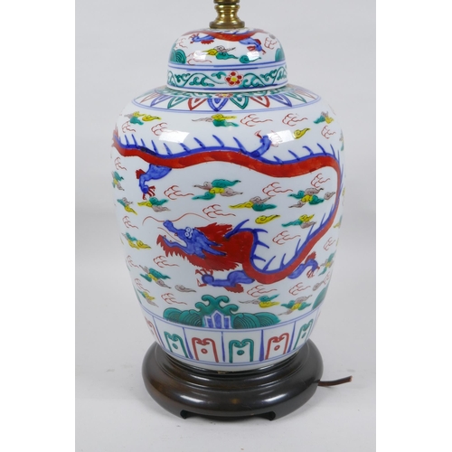 250 - A Chinese Wucai porcelain jar and cover with dragon decoration, converted to a lamp, 41cm high