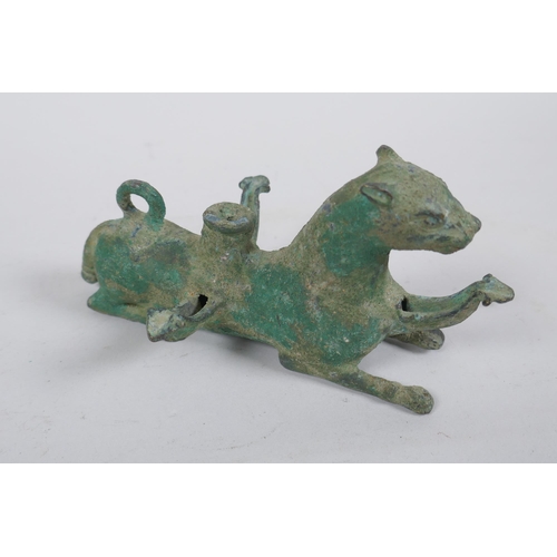 255 - A Persian cast metal oil lamp in the form of a lion, 15cm long