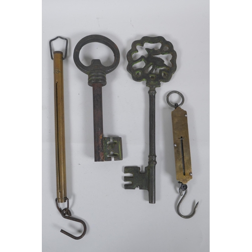 259 - Two antique Salter brass spring balance scales, and two cast iron oversized keys, largest 35cm