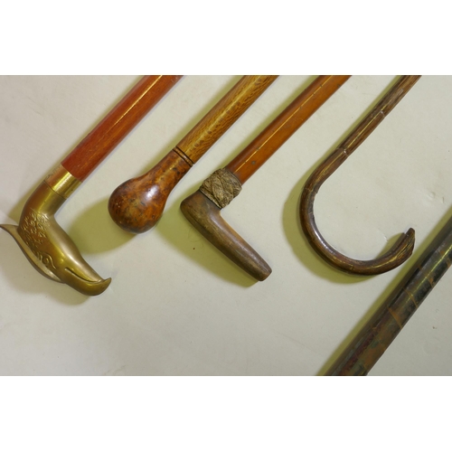 265 - Four vintage walking sticks with brass, horn, walnut and bamboo handles, together with a collapsable... 