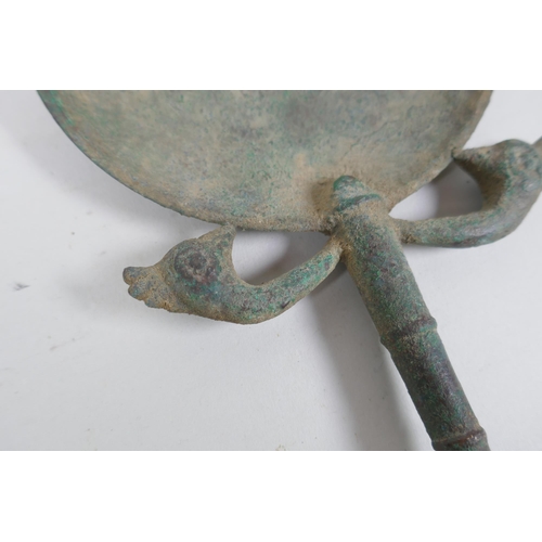 267 - An antique bronze hand mirror with bird head decoration, possibly Etruscan, 23cm long