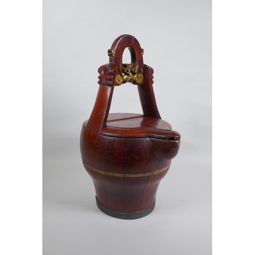 273 - An antique Chinese red lacquered wood basket with spout and carved handle, 40cm high