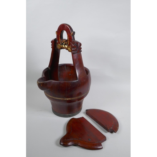 273 - An antique Chinese red lacquered wood basket with spout and carved handle, 40cm high