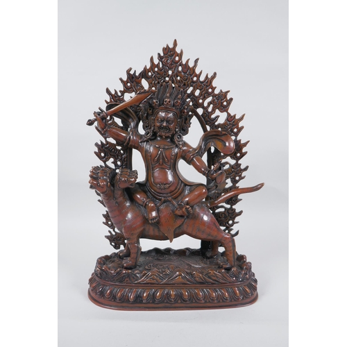 275 - A Tibetan coppered bronze figure of a wrathful deity riding a mythical creature, double vajra mark t... 