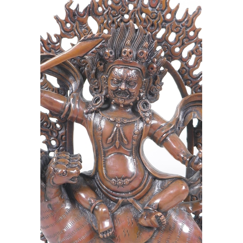 275 - A Tibetan coppered bronze figure of a wrathful deity riding a mythical creature, double vajra mark t... 