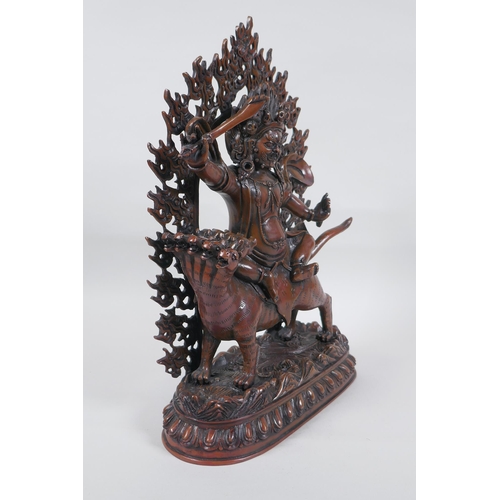 275 - A Tibetan coppered bronze figure of a wrathful deity riding a mythical creature, double vajra mark t... 