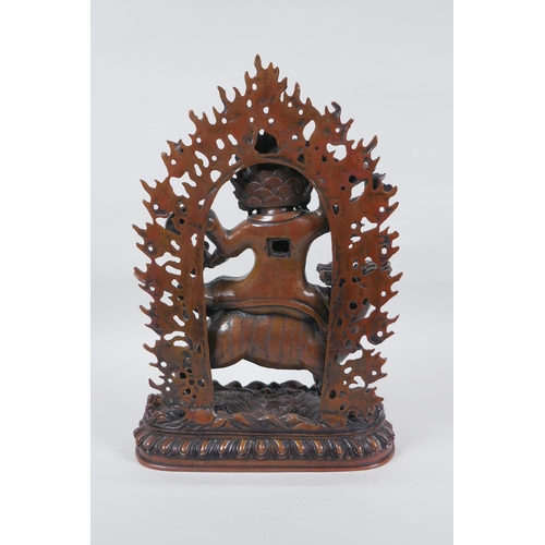 275 - A Tibetan coppered bronze figure of a wrathful deity riding a mythical creature, double vajra mark t... 