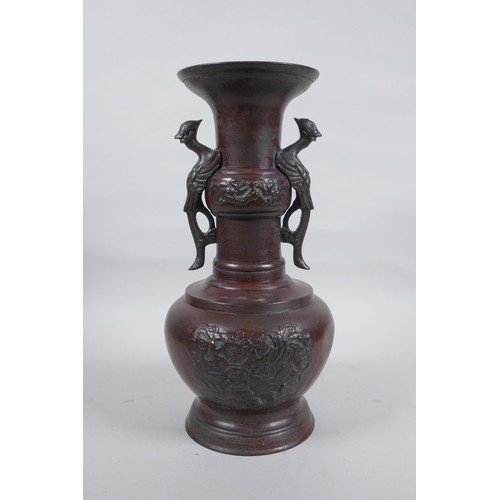 283 - A Chinese bronze vase with two phoenix handles and raised panels depicting dragons, 30cm high