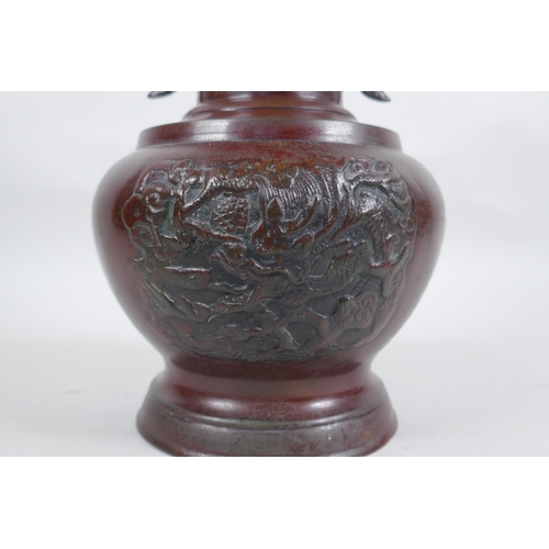 283 - A Chinese bronze vase with two phoenix handles and raised panels depicting dragons, 30cm high