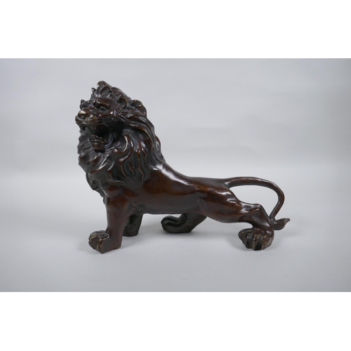 284 - A filled bronze figure of a lion, 26cm long