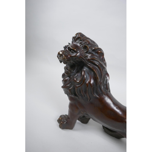 284 - A filled bronze figure of a lion, 26cm long