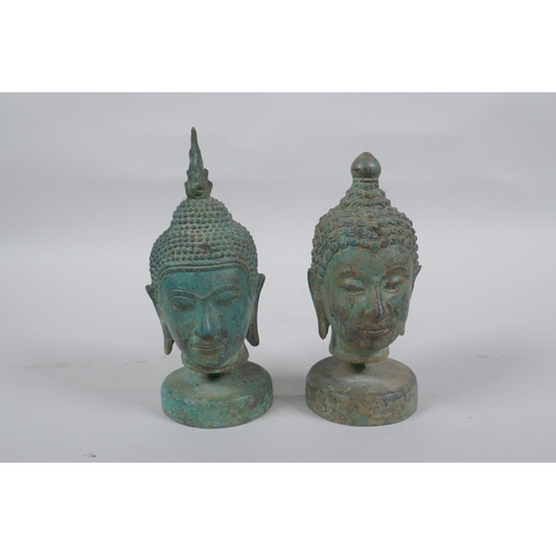 298 - A pair of bronze Buddha's heads with green patina, mounted on a metal stand, 16.5cm high