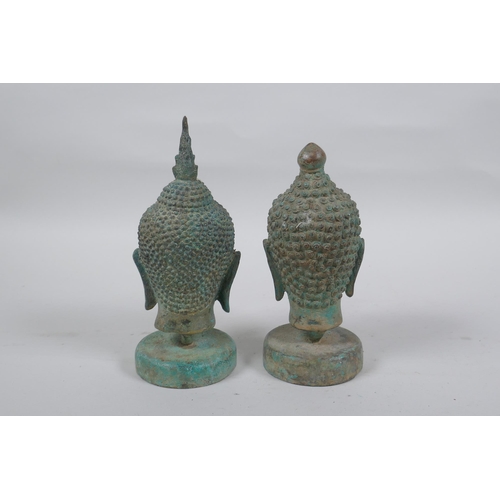 298 - A pair of bronze Buddha's heads with green patina, mounted on a metal stand, 16.5cm high