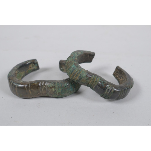 299 - Two antique bronze cash bangles, 8 x 6cm