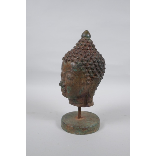 300 - A bronze Buddha head bust on a metal base, with green patina, 25cm high