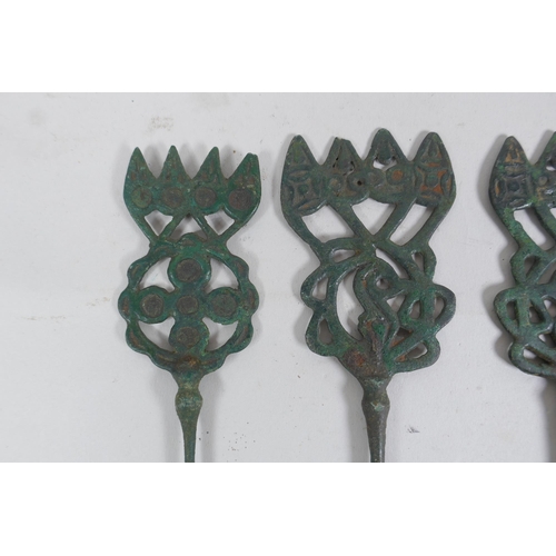 310 - Four antique copper markers with pierced decoration, 23cm long