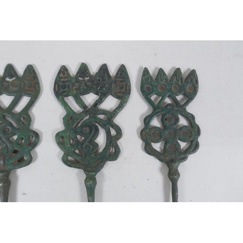 310 - Four antique copper markers with pierced decoration, 23cm long