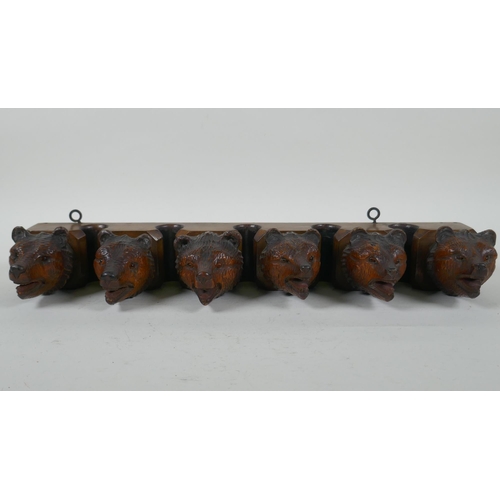 315 - An antique Black Forest carved wood pipe rack with bear's head decoration, a pair of turned wood tob... 