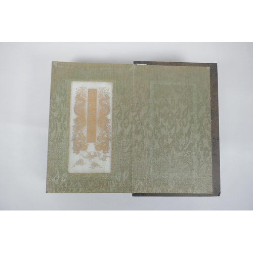 40 - A Chinese wood and silk bound book containing white jade tablet pages with chased and gilt inscripti... 