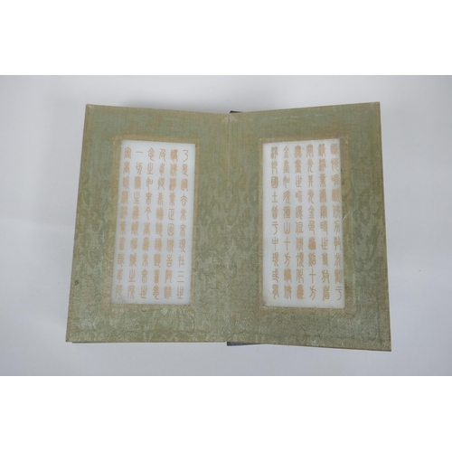 40 - A Chinese wood and silk bound book containing white jade tablet pages with chased and gilt inscripti... 